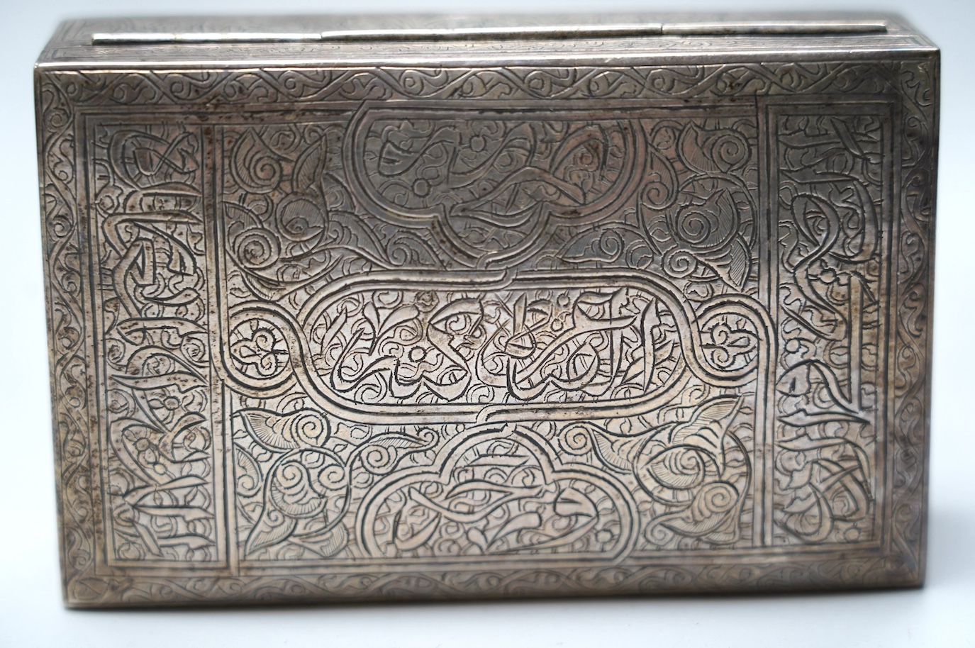 A Middle Eastern engraved white metal rectangular cigarette box, 12.5cm. Condition - fair